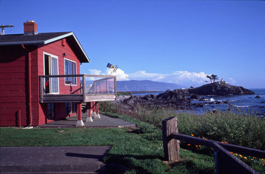 photo of battery point beach house with lighthouse in background