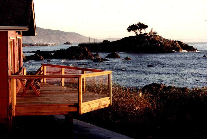 Photo of deck of battery point beach house with lighthouse in background